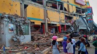 Warga melihat bangunan pusat perbelanjaan yang ambruk akibat gempa di Palu, Sulawesi Tengah. Antara Foto/Rolex Malaha.