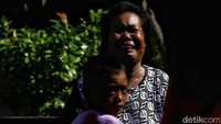 Seorang ibu menangis sambil menggendong anaknya usai terjadi gempa dan tsunami yang menghantam wilayah Palu, Sulawesi Tengah, Jumat (28/9/2018) malam. Warga harus merelakan rumah mereka hancur dan kehilangan keluarga akibat bencana tersebut, Sabtu, (29/9/2018).