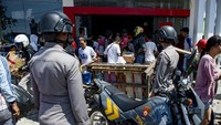 Polisi tampak mengawasi kondisi di depan salah satu minimarket (Foto: AFP PHOTO / BAY ISMOYO)