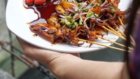 Kalau takut kolesterol melonjak karena makan sate kambing, coba ganti dengan sate cumi. Ini satenya disajikan dengan sambal kecap persis sate kambing. Foto  instagram lemburkuringmedan