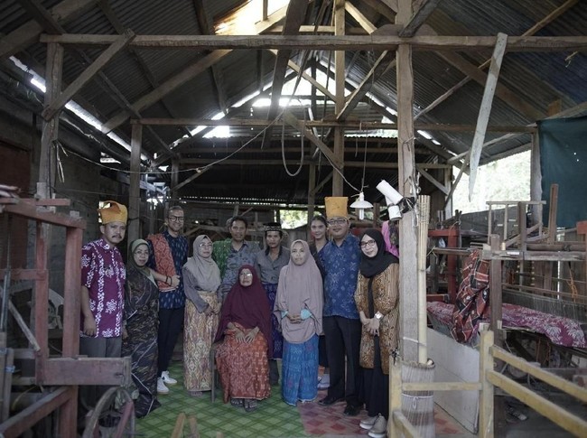 Didiet berfoto bersama para perajin tenun donggala. Saat ini, ia masih berusaha mengontak sejumlah perajin dan desainer lokal yang sempat dibinanya. Selain mendoakan keselamatan mereka, ia juga berharap tenun donggala tak punah akibat bencana gempa dan tsunami ini. Untuk urusan rehabilitasi dan pelestarian tenun pascabencana, aku pasti akan siap membantu, kata Didiet. (Foto: @bernardopictura via Didiet Maulana)