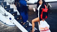 Ada yang unik nih pada pose Khloe Kardashian dan Kylie Jenner yang hendak naik pesawat jet. Yap! Kylie membawa sekantung besar fried chicken Popeyes. Foto: Istimewa
