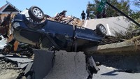 Tampak mobil terbalik akibat terseret arus tsunami.