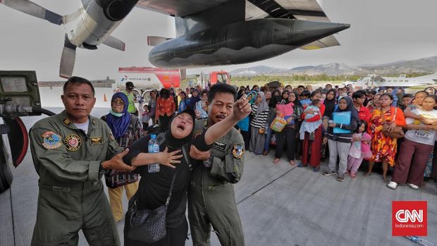 Warga histeris saat mencoba mengevakuasi diri dari Palu dengan pesawat Hercules di Bandara Mutiara Sis Al Jufri Palu, Sulawesi Tengah, Minggu (30/9).