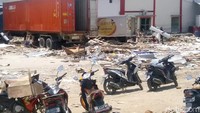 Sejumlah orang tampak membawa seng yang didapat dari pusat pergudangan tersebut.
