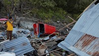 Tampak seorang warga sedang berdiri di reruntuhan rumahnya yang telah rata dengan tanah akibat diterjang tsunami dan gempa. Beawiharta/Reuters.
