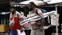 Dua orang warga Papua Nugini usai memborong belanjaan dari pasar.
