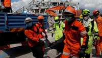 Tim penyelamat membawa korban tewas dari reruntuhan Hotel Roa Roa. REUTERS/Beawiharta.