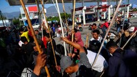 Warga berusaha membuka bunker BBM di salah satu SPBU, Selasa (2/10). REUTERS/Athit Perawongmetha.