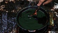 Canting dicelupkan ke dalam wajan yang berisi malam. Setelah itu canting digoreskan ke kain yang telah dipola.