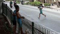 Sesekali bola harus keluar ke jalan raya.