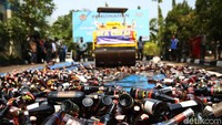 Sebanyak 2.245 botol miras ilegal dimusnahkan dengan cara digilas.
