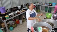 Dapur di shelter Kampung Kunir berukuran 5x3 meter yang terbuat dari seng dan beratap. Tampak seorang warga sedang memasak di dapur bersama di area shelter Kampung Kunir.