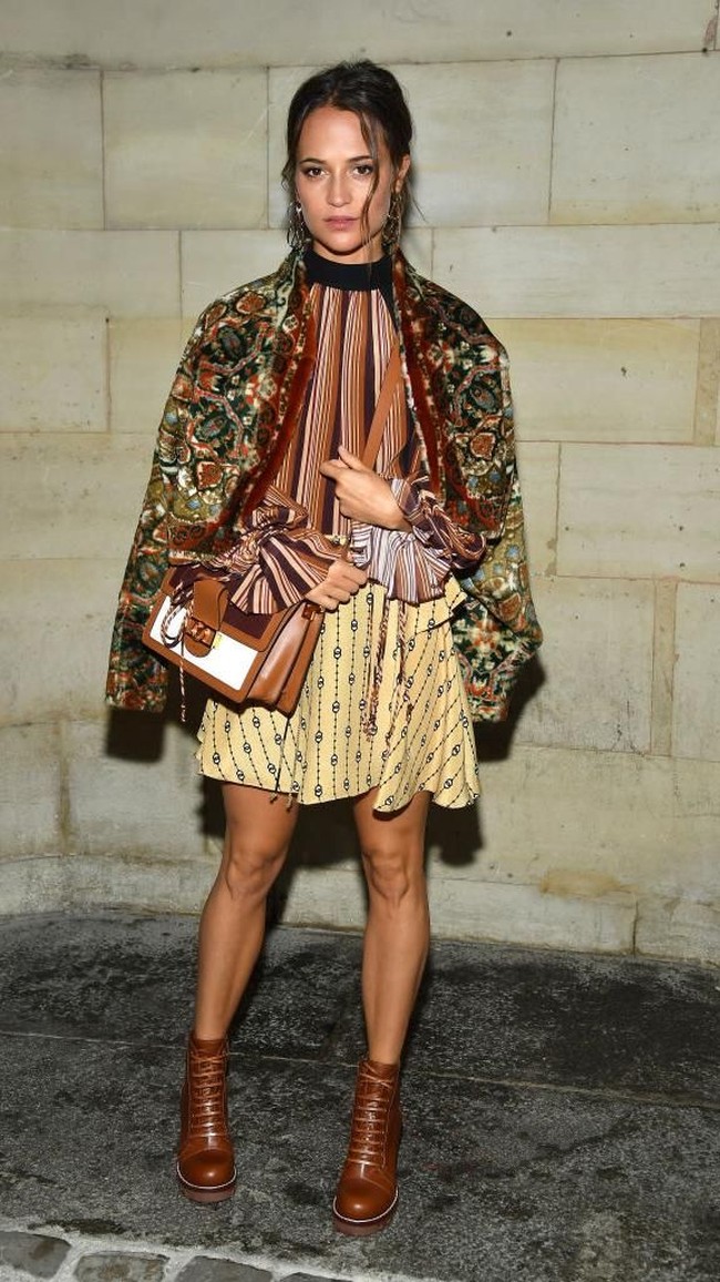Alicia Vikander muncul di fashion show Louis Vuitton yang menjadi penutup manis Paris Fashion Week, Selasa (2/10/2018). Aktris pemenang Oscars ini tampil stylish dengan atasan bergaya retro yang dibungkus jaket bergaya feminin. Tidak ketinggalan, rok kuning serta boots coklat. (Foto: Getty Images)