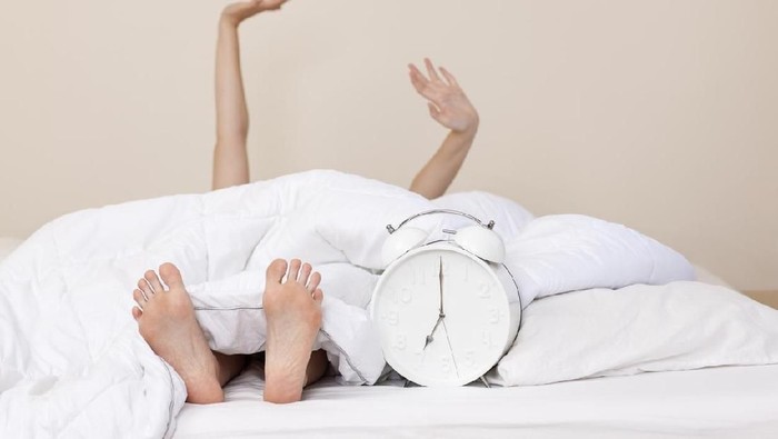 894745942 Good morning by stretching feet with pink socks out of the blanket. Choose focus point with copy space.