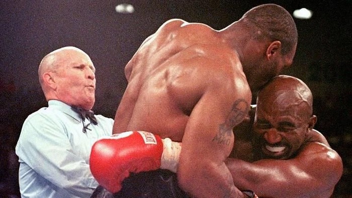 Referee Lane Mills (L) steps in as Evander Holyfield (R) reacts after Mike Tyson bit his ear in the third round of their WBA heavyweight championship fight at the MGM Grand Garden Arena in Las Vegas, NV 28 June. Holyfield won by disqualification after the biting incident.     AFP PHOTO/JEFF HAYNES / AFP PHOTO / JEFF HAYNES