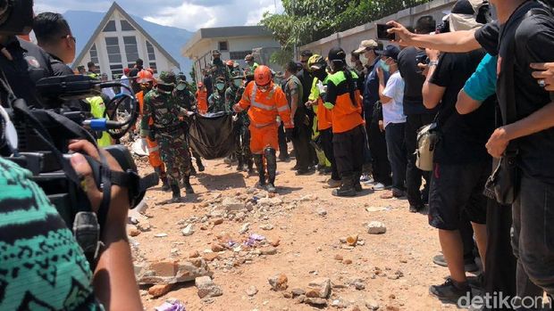 Petugas mengevakuasi jasad korban dari balik reruntuhan Hotel Roa Roa