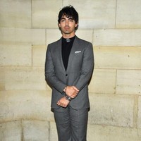Joe Jonas memilih gaya semi formal dengan setelan berpadu sneakers. (Foto: Getty Images)