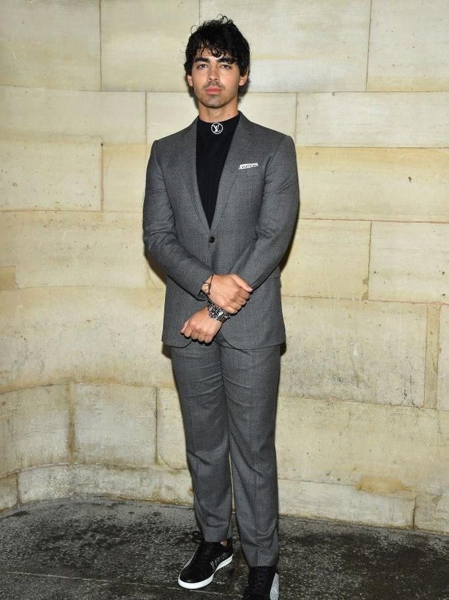 Joe Jonas memilih gaya semi formal dengan setelan berpadu sneakers. (Foto: Getty Images)