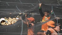 Dari bawah, para petugas mengangkat waring dan menggoyangkannya untuk memindahkan sampah-sampah tersebut.