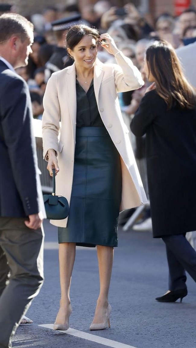 Bukan Meghan Markle jika tidak tampil stylish. Kali ini gayanya sedikit berbeda berkat rok kulit hijau jamrud dari Hugo Boss. (Foto: Getty Images)