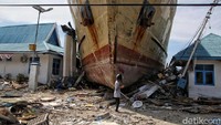 Warga melintas di depan KM Sabuk Nusantara 39 yang berada di Pelabuhan Wani, Kabupaten Donggala.