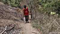 Selama mengungsi, warga terpaksa mencari sumber air yang lokasinya jauh dari tenda pengungsian.