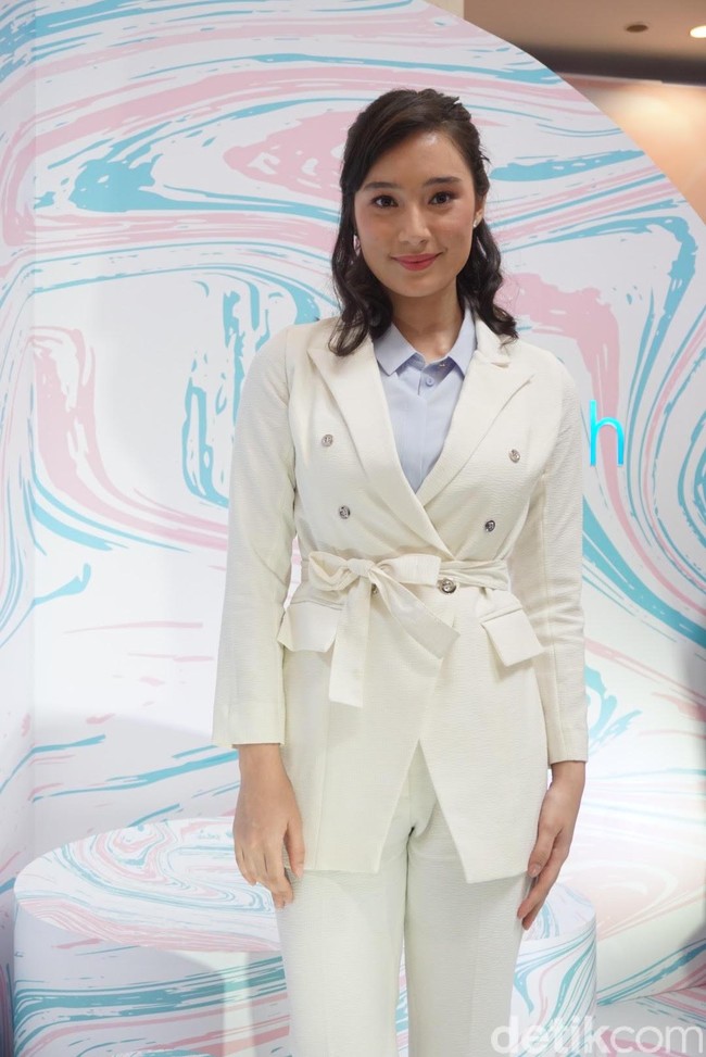 Wanita yang telah empat tahun didapuk menjadi brand ambassador Wardah ini mengenakan setelan blazer dan celana putih senada, sementara warna biru pada kemeja memberi sentuhan berbeda yang membuat looknya lebih kasual. Foto: Alissa Safera/Wolipop