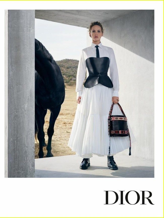 Gaya Jennifer berpose dengan dress putih yang dibungkus korset kulit hitam. Stylish! (Foto: Dok. Dior)