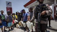 Polisi dan TNI bersenjata dikerahkan untuk menjaga SPBU, Rabu (3/10) kemarin. Ulet Ifansasti/Getty Images.