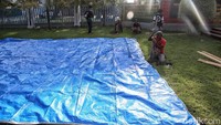 Para napi yang tidak kabur membantu petugas mendirikan tenda di halaman lapas.