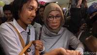Ratna hadir memakai baju putih dan kerudung cokelat. Barang-barang ratna, seperti koper, dimasukkan ke bagasi mobil bertulisan Jatanras Polda Metro Jaya.