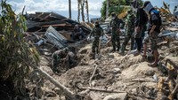 Anggota TNI melakukan penggalian untuk mengangkat jenazah korban gempa. Carl Court/Getty Images.