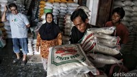 Pedagang beras melayani pembeli.