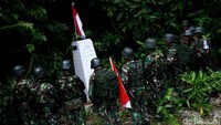 Tiang Sang Saka ditancapkan di patok, Merah Putih berkibar. Para personel Satgas Pamtas membentuk formasi setengah lingkaran menghadap ke patok dan memberi hormat ke Merah Putih.