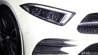 Lampu depan Mercedes-Benz CLS yang sangat datar dan lebar dengan sisi yang condong ke arah dalam mengikuti kontur grille secara dinamis.