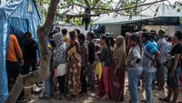 Di bagian lain di kota Palu, warga tampak mengantre untuk mendapatkan bantuan pascagempa dan tsunami yang telah menghancurkan rumah dan seluruh harta benda mereka pada Jumat (28/9/2018). Carl Court/Getty Images.