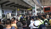 Petugas bandara memberikan penjelasan kepada calon penumpang.