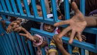 Anak-anak pun tampak turut bergabung mengantre untuk mendapatkan bantuan. Carl Court/Getty Images.