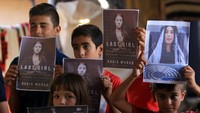 Anak-anak Yazidi tampak memegang gambar Nadia Murad di kota Duhok, Irak pada 5 Oktober 2018 usai diumumkannya Murad sebagai pemenang hadiah Nobel Perdamaian 2018. Foto: Reuters