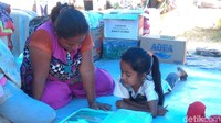 Mereka belajar dengan membaca buku pelajaran di bawah naungan tenda pengungsian. Nyala semangat belajar mereka tak bisa dipadamkan oleh tsunami. (Bil Wahid/detikcom)