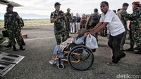 Warga menaiki pesawat menggunakan kursi roda.