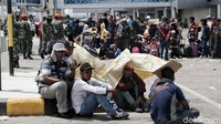 Beberapa warga melindungi diri dari sinar matahari menggunakan tikar di Bandara Mutiara Al Sis Jufri Palu.