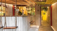 Bar ini menggunakan warna-warna yang ceria, mulai dari pintu, ayunan yang digunakan tempat duduk hingga warna dinding. Istimewa/Inhabitat/Dirk Weiblen.
