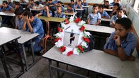 Teman-teman sekolah Nassir al-Mosabeh duduk sambil berderai air mata di ruang kelas di Khan Younis, Minggu (7/10), saat foto Nassir dihadirkan. (Foto: Dok. REUTERS/Ibraheem Abu Mustafa)