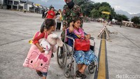 Korban gempa tiba di Bandara Mutiara Al Sis Jufri dengan dibantu prajurit TNI, Sabtu (6/10/2018).
