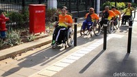 Sejumlah suporter Asian Para Games 2018 melintas di trotoar yang telah dilengkapi dengan jalur khusus penyandang disabilitas.