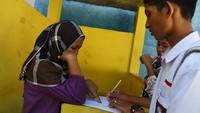 Tampak siswa sedang mendata rekannya saat hari pertama masuk sekolah di SMA PGRI kota Palu, Sulawesi Tengah, Senin (8/10/2018). Istimewa/Antara Foto/Wahyu Putro A.