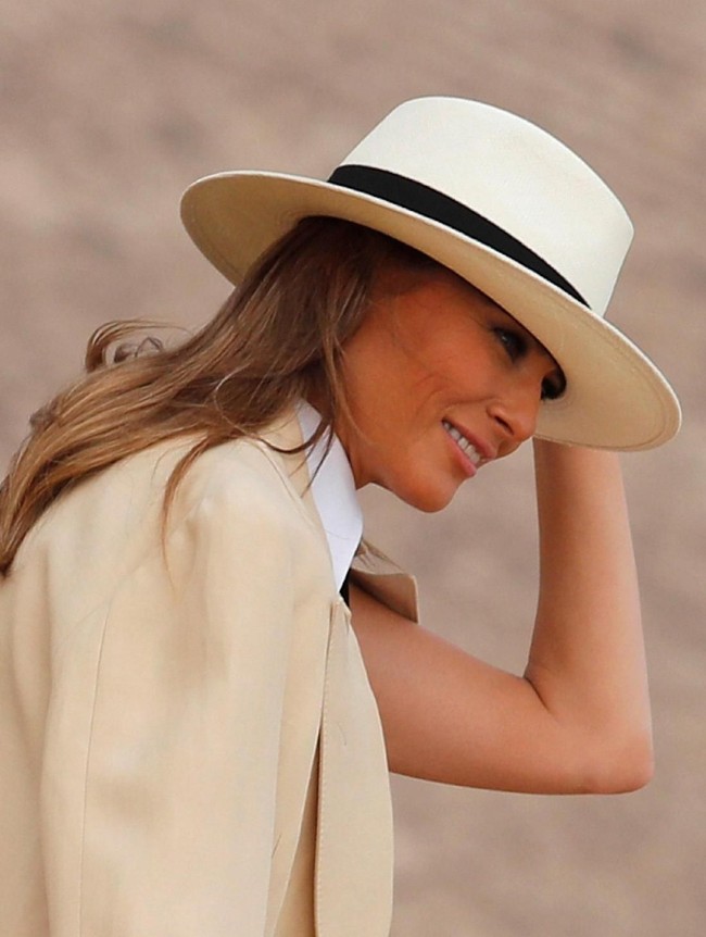 Sang Ibu Negara juga menyempurnakan gayanya dengan topi fendora berhiaskan korsase. Tidak ketinggalan sepasang heels Chanel untuk menopang kakinya. (Foto: REUTERS/Carlo Allegri)
