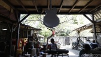 Pekerja merampungkan pembuatan gitar di rumah produksi milik Tuges yang terletak di Jalan Baruna No. 5 Guwang, Sukowati, Bali.